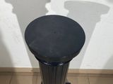 a black trash can sitting on the floor next to a white wall