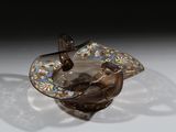 un cendrier en verre orné d'un oiseau