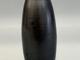 a black vase that is sitting on a white surface