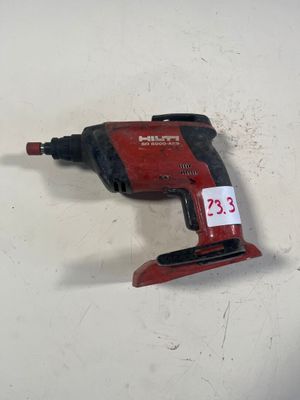 un gros plan d'une perceuse filaire posée sur une surface blanche