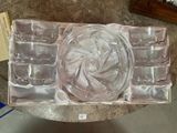 un saladier en verre et six verres dans une boîte posée sur une table