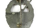 a silver brooch with a metal pin on it