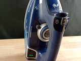 a blue iron that is sitting on a wooden table