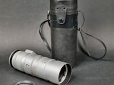 a camera lens and a leather case on a table