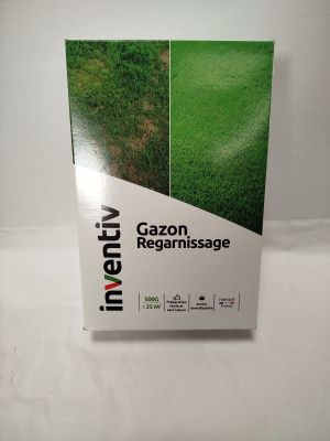 un gros plan sur une boîte remplie d'herbe verte posée sur une surface blanche