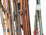 many different types of fishing rods hanging on the wall