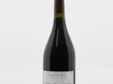 une bouteille de vin posée sur une table à côté d'une bouteille de vin