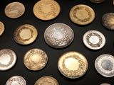 a lot of gold and silver plates on a black table
