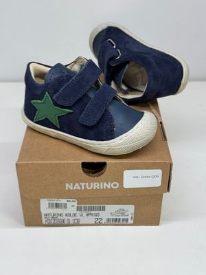 chaussures de petit garçon dans une boîte ornée d'une étoile sur le côté