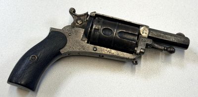 un petit pistolet posé sur une surface blanche