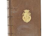 a brown leather book with a gold emblem on the cover