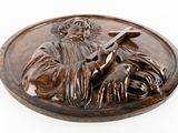 statue of a man holding a cross on a plaque