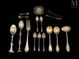 de nombreuses cuillères en argent et cuillères à soupe sur fond noir