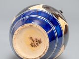 a blue and white vase with a gold rim