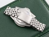 a watch sitting on a green box on a white surface
