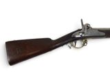 un vieux fusil avec une poignée en bois sur fond blanc
