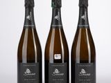trois bouteilles de vin posées l'une à côté de l'autre sur une table