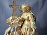a statue of a woman standing next to a cross