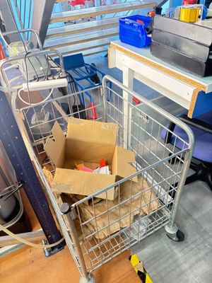 un caddie posé par terre, avec une boîte à l'intérieur