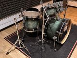 a drum set sitting on a rug in a recording room