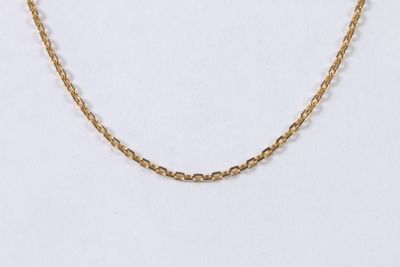 gros plan d'un collier en chaîne en or sur fond blanc