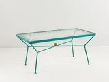 une table basse en verre avec une structure en métal et un plateau en verre