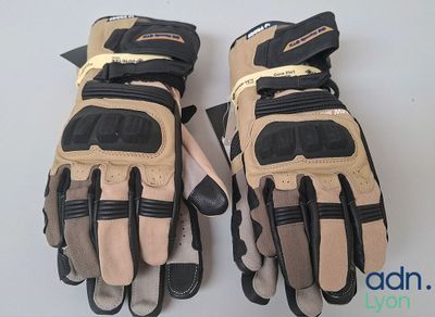 Deux paires de gants de moto sont présentées sur un fond blanc.