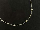 a necklace with pearls and gold beads on a black background