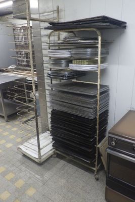 many trays and pans on a rack in a kitchen