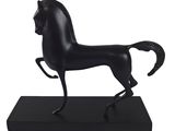 statue d'un cheval noir posée sur un socle noir, sur fond blanc
