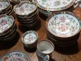 many plates and cups sitting on a table together