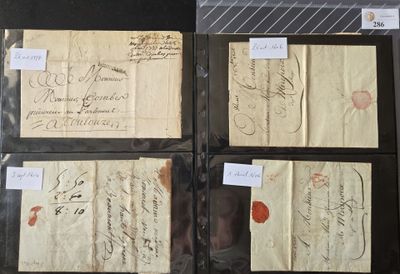 quatre vieux morceaux de papier sur lesquels sont écrits des mots, posés sur une table