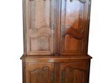 a wooden cabinet with two doors and a drawer underneath it