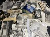 pile of old black and white photographs of people and buildings