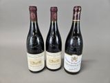 trois bouteilles de vin posées sur une table, l'une à côté de l'autre