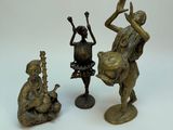 trois figurines en bronze représentant un homme jouant d'un instrument de musique