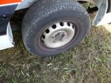 a flat tire on a flatbed truck that is parked in the grass