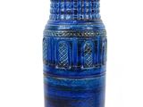 a blue vase that is sitting on a white surface