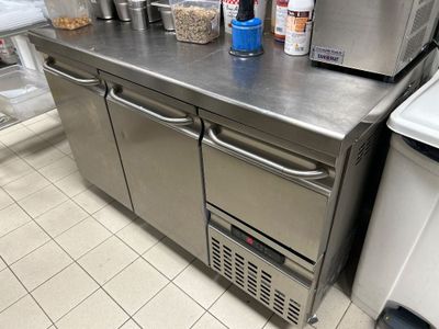 plan de travail en acier inoxydable dans une cuisine commerciale équipée d'appareils en acier inoxydable