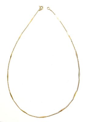 gros plan d'un collier en or sur fond blanc