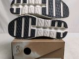 the soles of a pair of black and white running shoes on top of a cardboard box