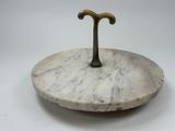 a white marble plate with a brass handle on it