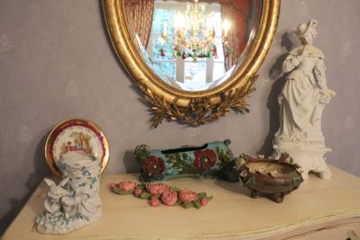a table with a mirror and a statue on it
