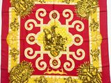 une écharpe carrée rouge et dorée ornée d'un crâne