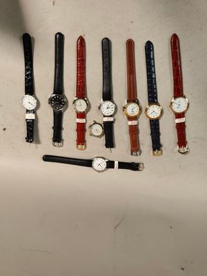 plusieurs montres et un stylo posés sur une table