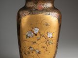 a gold vase with a floral design on it