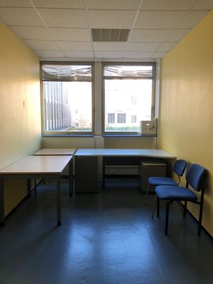 une pièce dans laquelle se trouvent deux bureaux et deux chaises