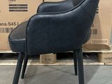a black chair that is sitting in front of a stack of boxes