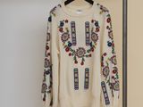 an image of a sweater hanging on a hanger in a room