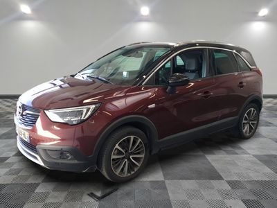 une voiture rouge garée sur un sol à damier dans un showroom
